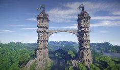 an aerial view of two tall towers in the middle of a forest with blue sky and clouds