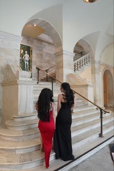 two women are standing on the stairs looking at each other