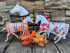 three horse figurines sitting on top of a wooden table