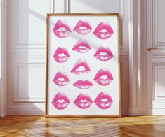 a framed photo with pink lipstick prints on it in front of a white wall and wooden floor