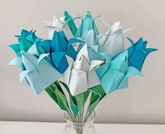 origami flowers in a glass vase on a table