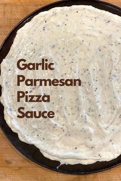 A pizza crust covered in white sauce on a pizza pan. Garlic Cream Pizza Sauce, Creamy Garlic White Pizza Sauce, How To Make White Pizza Sauce, Garlic Sauce For Pizza Crust, Buttery Garlic Sauce For Pizza, Best White Pizza Sauce, How To Make A White Pizza, Pizza Sauces Ideas, Garlic Parmesan Sauce For Pizza