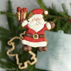 a christmas ornament hanging from a tree with a santa clause on it's back