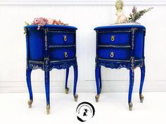 two blue nightstands with flowers on top and the bottom one is painted in royal blue