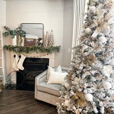 a living room decorated for christmas with white and gold decorations