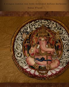 an ornately decorated ganesha on a gold and white plate with words above it