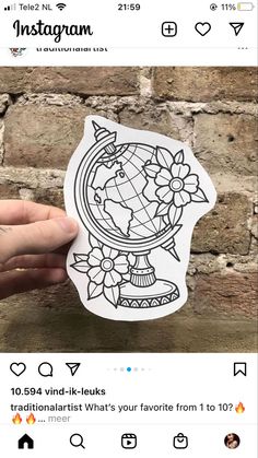 someone is holding up a sticker with an image of the earth and flowers on it