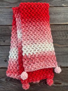 two red and white crocheted blankets sitting on top of a wooden table