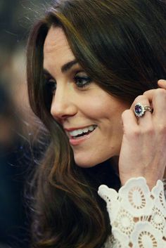 a close up of a person with a ring on her finger and wearing a dress