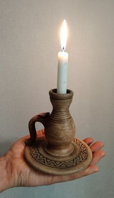 a person holding a small candle in their hand