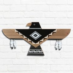 an eagle clock is hanging on the wall next to a white brick wall with black and brown accents