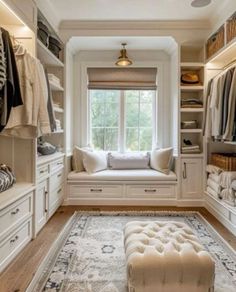 a walk in closet filled with lots of white furniture and drawers next to a window