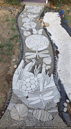 this is an image of a sidewalk made out of rocks and stones with flowers painted on it