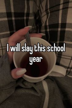 someone holding a cup with tea in it that says i will stay this school year