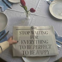 a newspaper sitting on top of a table with plates and utensils around it