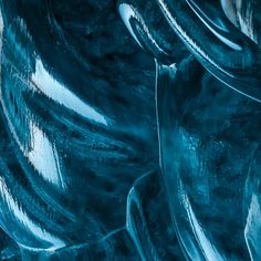 an abstract photograph of blue glass with wavy lines on the bottom, and dark edges