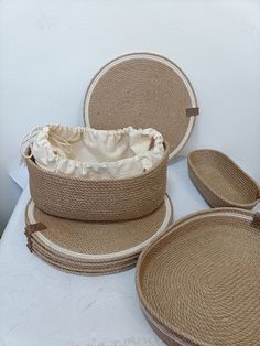 three woven baskets and two round placemats on top of a white tablecloth