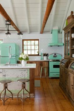 an old fashioned kitchen with green appliances and wood floors