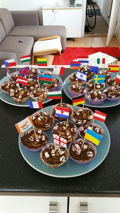 cupcakes with flags on them sitting on a table in front of a couch