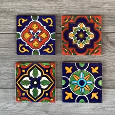 four colorful tiles are arranged on a wooden surface