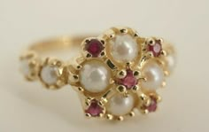 This is a very beautiful 14k yellow gold ring with 8 beautiful pearls and 5 ruby's. The ring is a size 7.25 and is 11mm wide at the top. The 4 pearls on the top of the ring are each approximately 4mm in diameter. The 4 on the side of the band are each 2.85mm. Also on the top of the ring are 5 ruby's that come to approximately 0.25ct. This a very beautiful and elegant ring that you will absolutely love!  Guaranteed to be 100% authentic.  DO NOT MISS OUT ON THESE BEAUTIFUL RINGS AND OTHER FINE JEW Pearl Rings Vintage Antique, Classic Multi-stone Cluster Ruby Ring, Fine Jewelry Rings For Anniversary With Jewels, Fine Jewelry Rings For Anniversary, Anniversary Fine Jewelry Rings With Jewels, Classic Multi-stone Cluster Ring For Wedding, Elegant Ruby Ring With 17 Jewels, Timeless Multi-stone Wedding Rings, Elegant Jewel Promise Ring