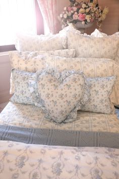 a bed with blue and white pillows on top of it next to a flower pot