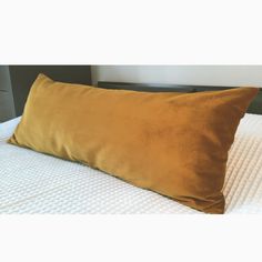 a brown pillow sitting on top of a white bed