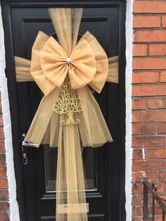 a black door with a yellow bow and leopard print ribbon on the front entrance to a brick building