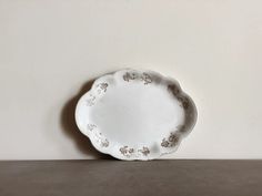 a white plate sitting on top of a table next to a brown and white wall