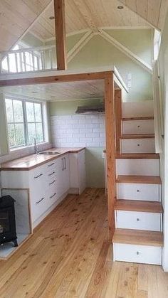 an empty kitchen with stairs leading up to the second floor and a stove top oven