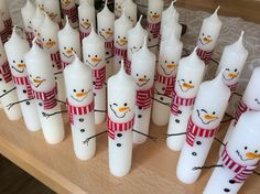 snowman candles are lined up on a table