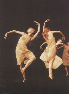 two women in yellow dresses are dancing on stage