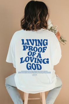 Introducing our new "Living Proof of a Loving God " t-shirt, a perfect expression of faith and style. This Christian shirt features a timeless design and a powerful message. This shirt is not only a fashionable choice but also a meaningful one. It serves as a reminder of the saving grace of Jesus Christ and the hope and redemption that comes with it. It's a great way to boldly express your faith and share your beliefs with others! ⁑ F U N ⁑ F A C T S ⁑ ☼ Unisex Adult Sizes ☼ 100% Cotton ☼ Washer Inspirational Short Sleeve Streetwear T-shirt, Inspirational Short Sleeve T-shirt For Streetwear, Bible Verse T Shirt, Jesus Clothes, Christian Shirts Designs, Aesthetic Christian, Christian Streetwear, Loving God, Christian Men