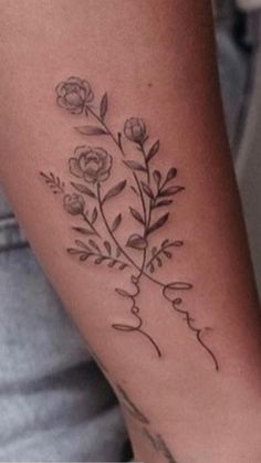 a woman's arm with flowers on it and the word love written in cursive