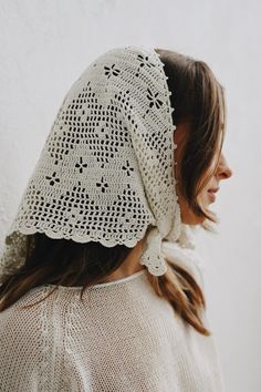 a woman wearing a white crochet head scarf