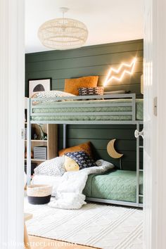 a bunk bed in a room with green walls and white trim on the bottom level