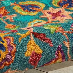 a colorful rug is laying on top of a wooden floor and it looks like something out of an old book