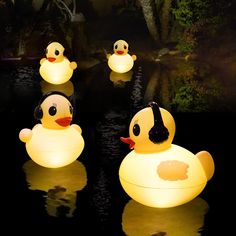 four rubber ducks floating in the water at night