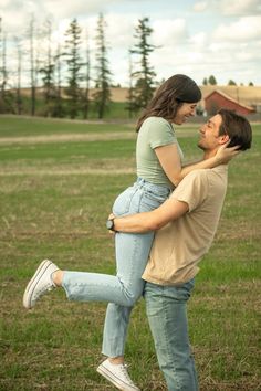 a man carrying a woman on his back in an open field with trees and grass