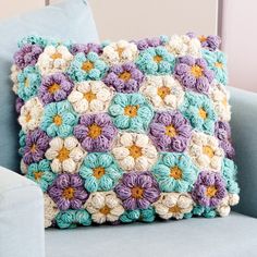 a crocheted pillow sitting on top of a blue couch