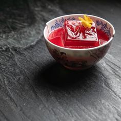 a bowl filled with red liquid sitting on top of a table