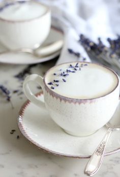 two cups and saucers with lavender sprigs on them