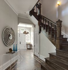 a staircase leading up to the second floor in a house with hardwood floors and white walls