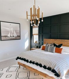 a bedroom with a bed, chandelier and pictures on the wall above it