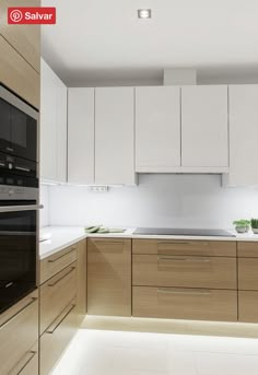 a modern kitchen with white cabinets and light wood flooring on the countertops, along with an oven