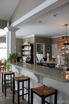 a kitchen filled with lots of counter top space and stools next to an island