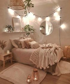 a bedroom decorated with lights and blankets on the bed, rugs in front of it