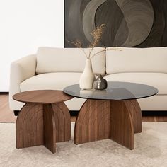 a living room with a couch, table and vase on the floor in front of it