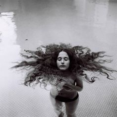 a woman with long hair standing in the water