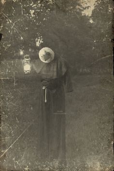 an old photo of a woman with a lantern in her hand